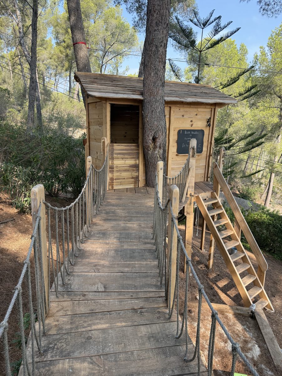 Puente colgante de acceso a cabaña en árbol